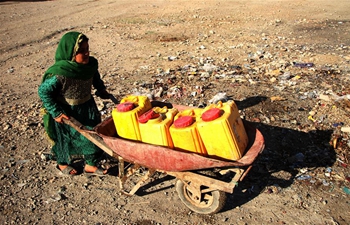 Afghan people fetch water from public water pump at displaced camp in Nangarhar