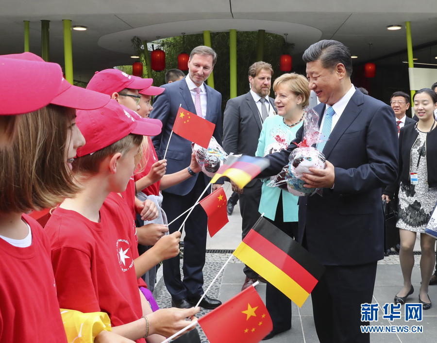 7月5日，国家主席习近平同德国总理默克尔共同出席柏林动物园大熊猫馆开馆仪式。这是习近平向现场的孩子们赠送大熊猫毛绒玩具。 新华社记者谢环驰 摄